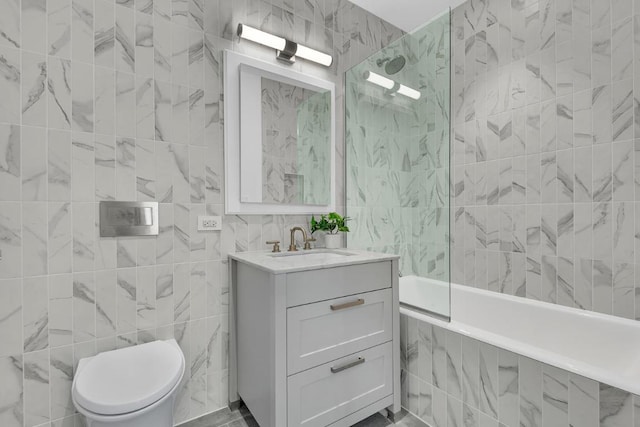 full bathroom featuring tile walls, tiled shower / bath combo, vanity, and toilet