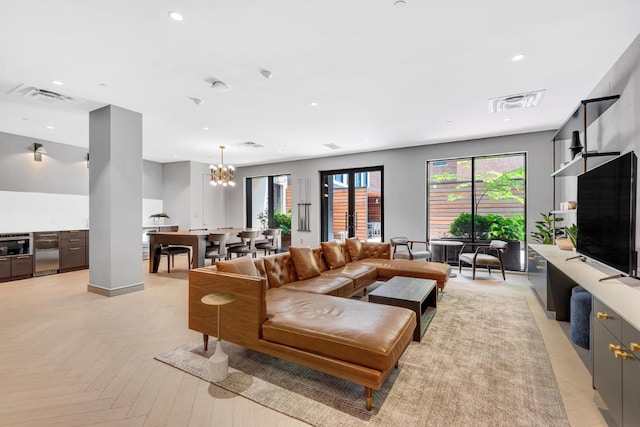 living room with light parquet flooring and a notable chandelier