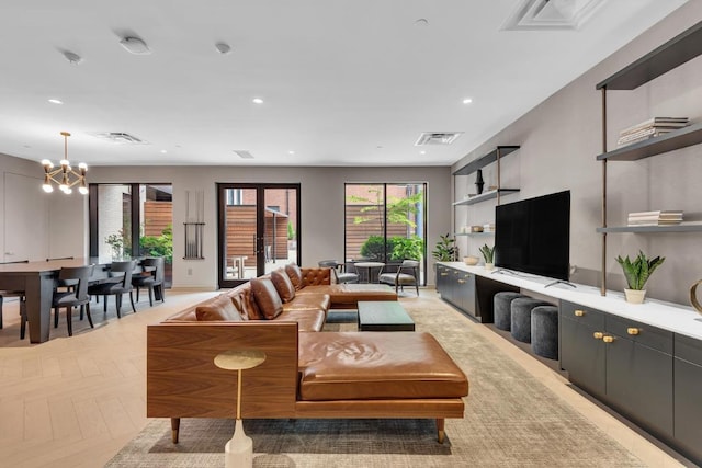 living room with a chandelier and light parquet flooring