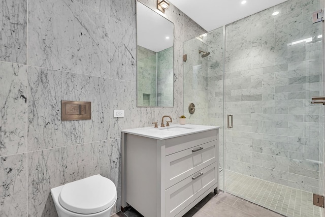 full bath with tile walls, a stall shower, tile patterned flooring, vanity, and toilet