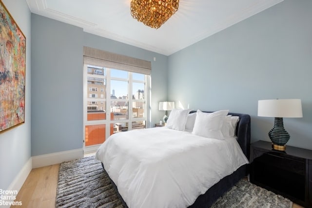 bedroom featuring ornamental molding and wood-type flooring