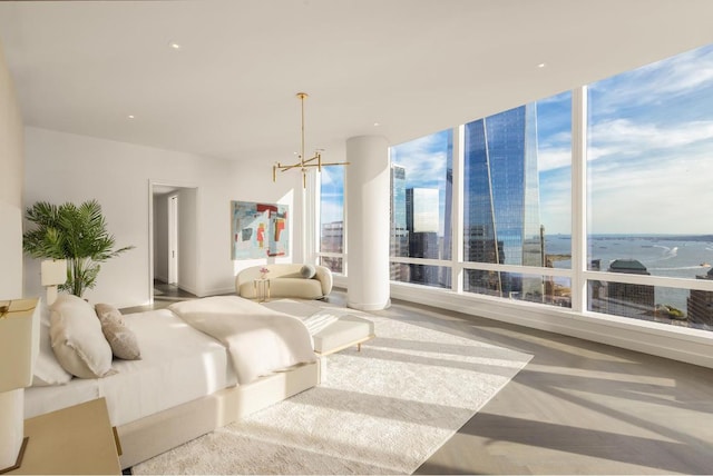 bedroom featuring multiple windows, a chandelier, and a water view