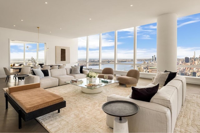 living room featuring a view of city, recessed lighting, and a water view