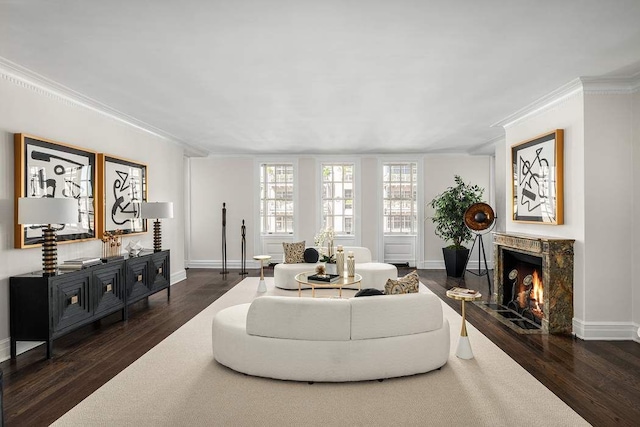 living area with a high end fireplace, dark wood-type flooring, baseboards, and ornamental molding