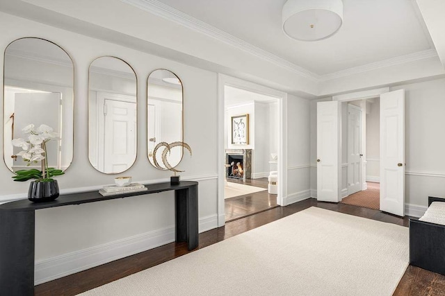 bedroom featuring dark wood-style floors, a warm lit fireplace, and crown molding