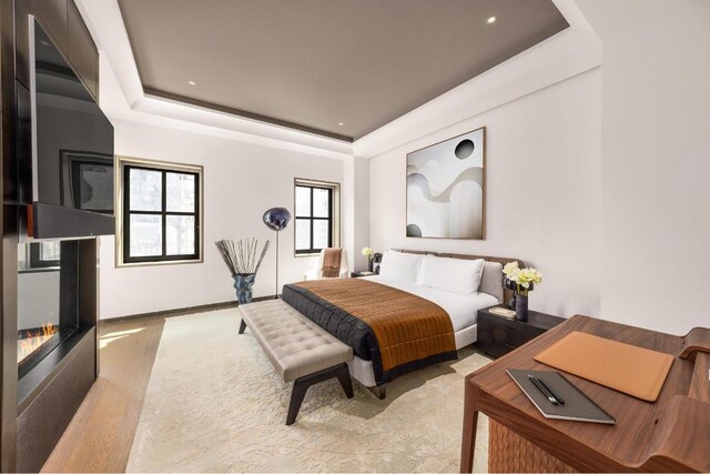 dining area with hardwood / wood-style flooring, plenty of natural light, and a raised ceiling