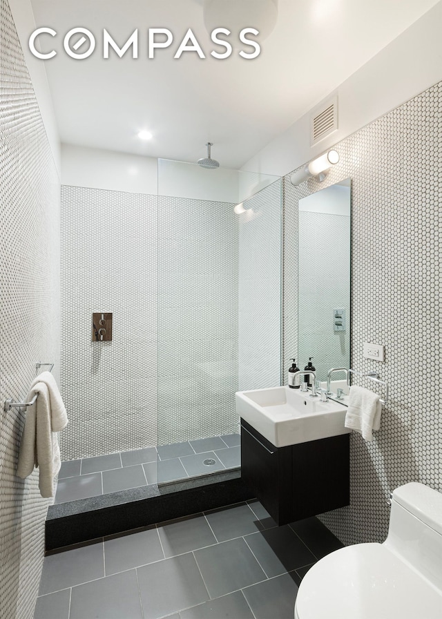 bathroom featuring visible vents, toilet, tile patterned floors, walk in shower, and vanity