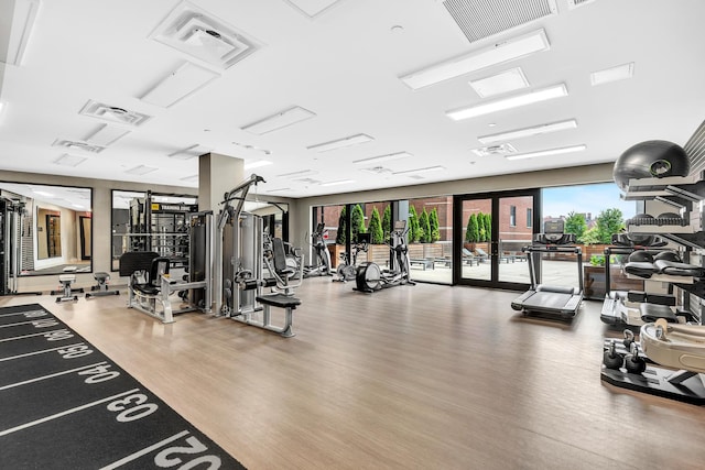 gym with a wealth of natural light, visible vents, and wood finished floors