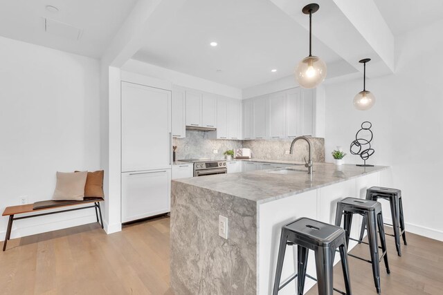 107-06 Queens Blvd Unit 7-G, New York City, NY 11375 - kitchen featuring a peninsula, a sink, a kitchen bar, stainless steel electric range, and tasteful backsplash