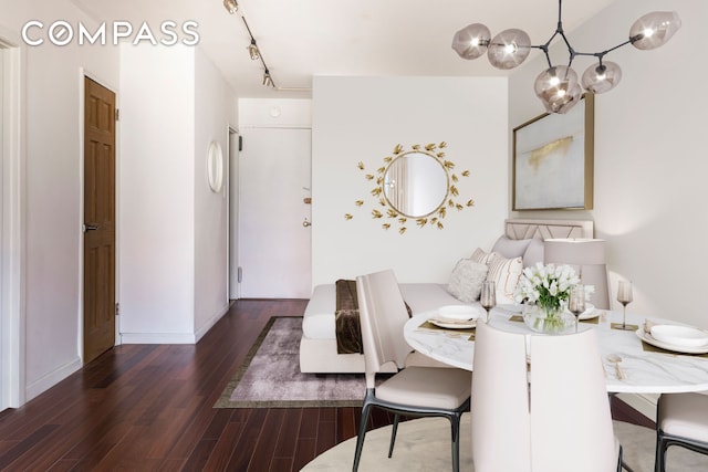 dining space with baseboards, track lighting, and wood finished floors