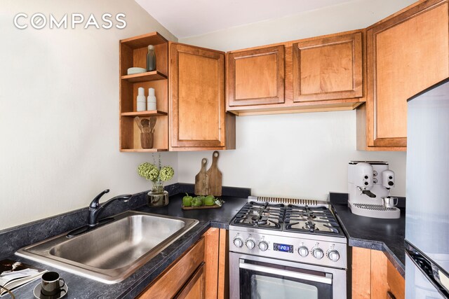 201 W 21st St Unit 7D, New York City, NY 10011 - kitchen with stainless steel gas range oven, a sink, dark countertops, brown cabinetry, and fridge