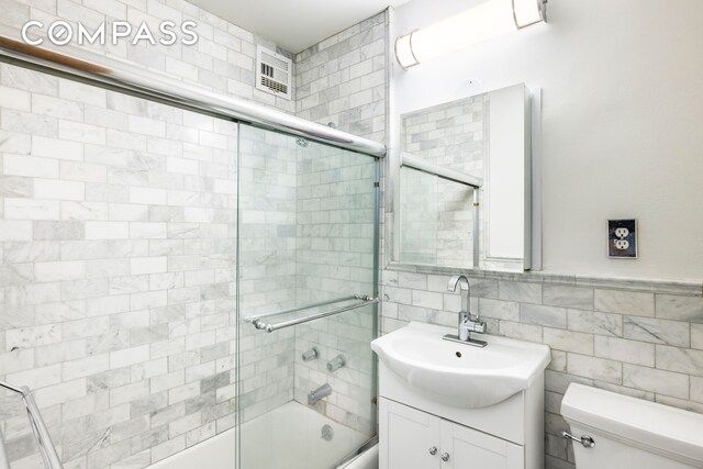 201 W 21st St Unit 7D, New York City, NY 10011 - bathroom with vanity, toilet, combined bath / shower with glass door, and tile walls