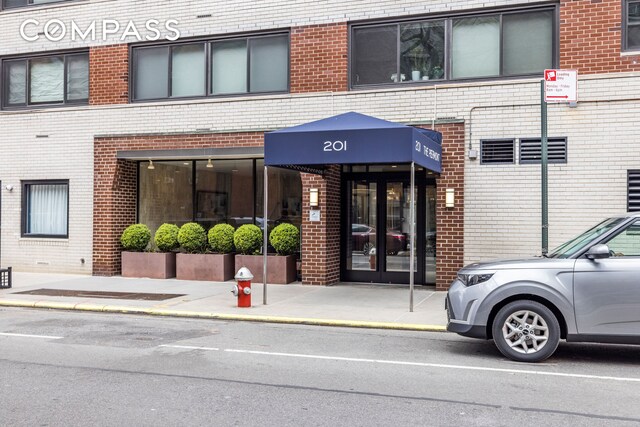 201 W 21st St Unit 7D, New York City, NY 10011 - view of exterior entry featuring brick siding and french doors