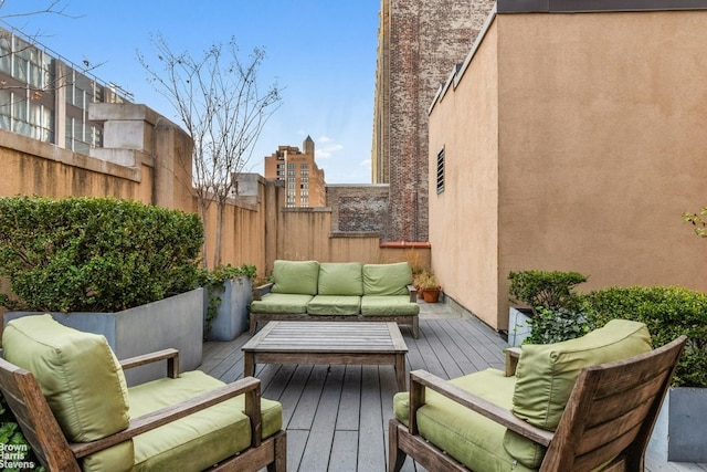 wooden deck with an outdoor living space and fence