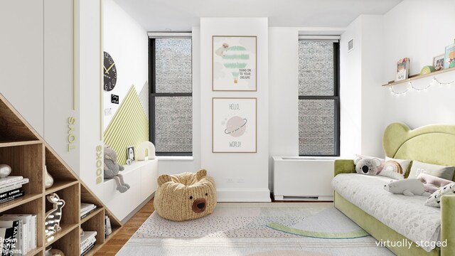 bedroom with visible vents, baseboards, and wood finished floors