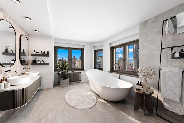 bathroom featuring vanity, radiator, and a bathtub