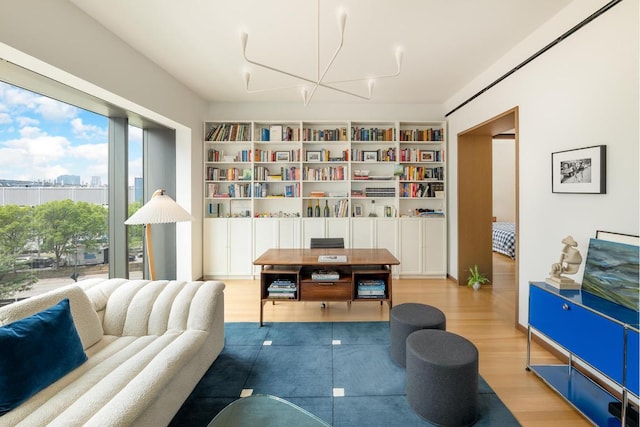 living area with built in features, a chandelier, and hardwood / wood-style flooring