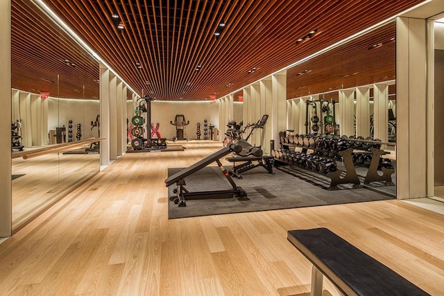 gym featuring light hardwood / wood-style floors and wood ceiling