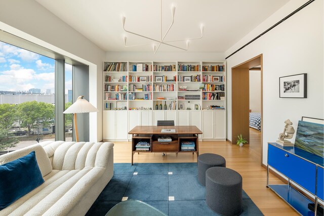 sitting room featuring a notable chandelier, a city view, and wood finished floors