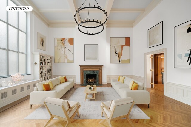 living room featuring a premium fireplace, light parquet flooring, an inviting chandelier, and beamed ceiling