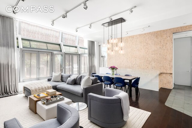 living area featuring rail lighting, a notable chandelier, and wood finished floors