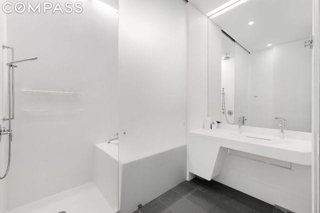 bathroom featuring tile patterned flooring, shower with separate bathtub, and dual sinks