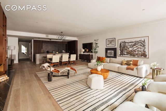 living room featuring a notable chandelier and dark wood-style floors