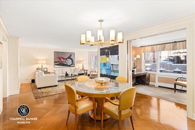 dining area featuring light parquet flooring, crown molding, and a notable chandelier