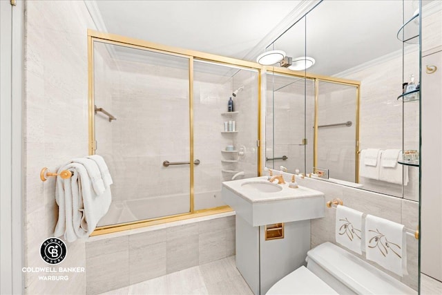 bathroom with tiled shower / bath, a sink, toilet, and crown molding