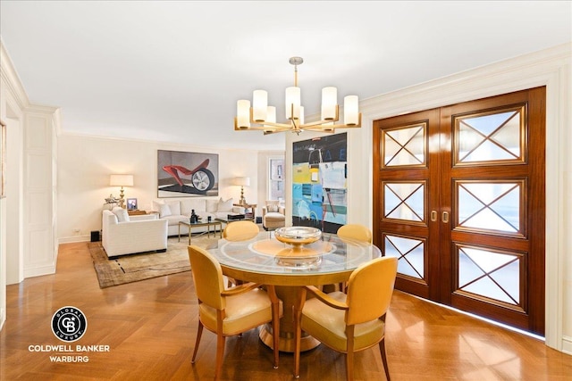 dining space featuring baseboards, a chandelier, and crown molding