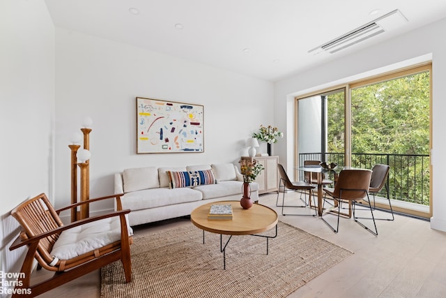 living room with light wood-style flooring and visible vents