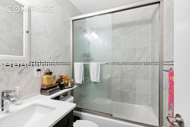 397 5th Ave, New York City, NY 11215 - full bathroom featuring bath / shower combo with glass door, vanity, decorative backsplash, and toilet