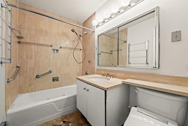 full bathroom with vanity, tiled shower / bath, toilet, and a textured ceiling