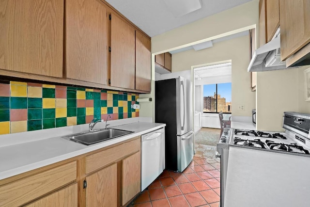 kitchen with tasteful backsplash, sink, white appliances, and light tile patterned floors