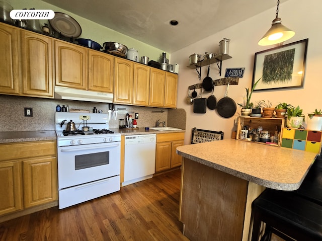 kitchen featuring hanging light fixtures, white appliances, dark wood-type flooring, decorative backsplash, and sink