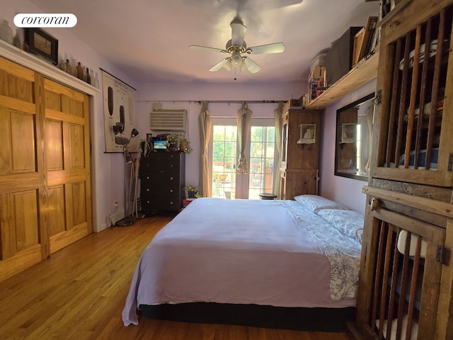 563 20th St, New York City, NY 11218 - bedroom featuring access to outside, wood finished floors, a wall mounted air conditioner, and a ceiling fan