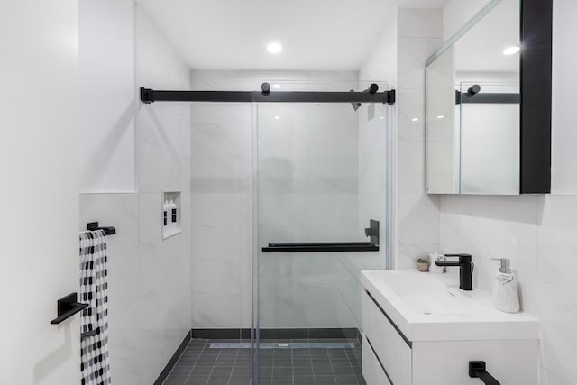 bathroom featuring tile walls, walk in shower, and vanity