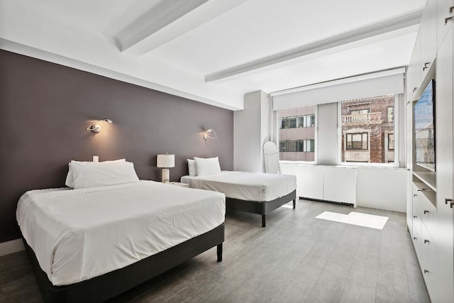 bedroom featuring hardwood / wood-style floors and beamed ceiling