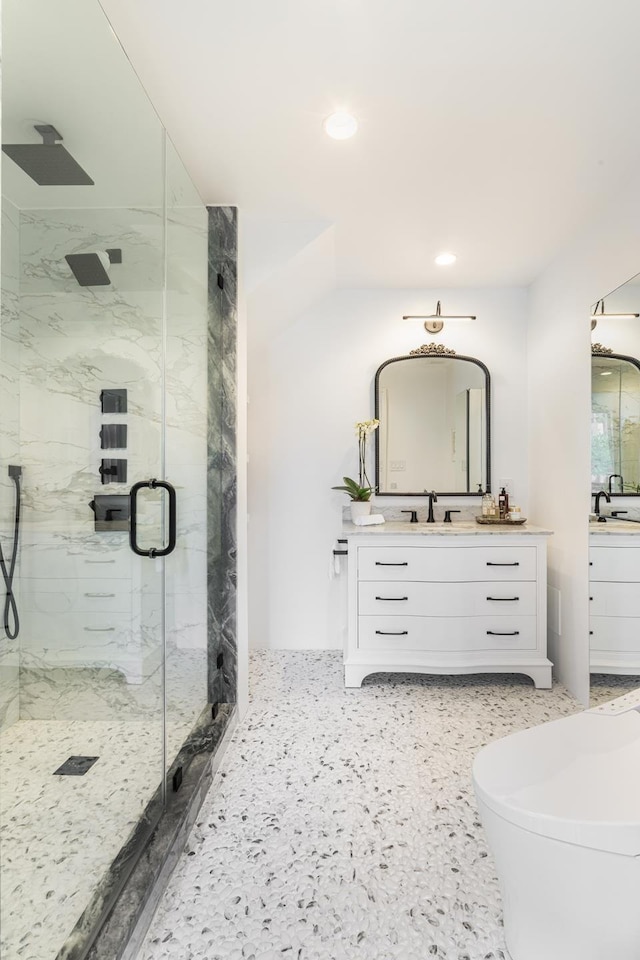 full bathroom featuring recessed lighting, a marble finish shower, and vanity