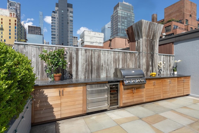 view of patio / terrace with wine cooler, a city view, and area for grilling