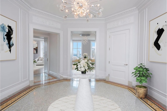 entryway featuring a decorative wall, baseboards, an inviting chandelier, and ornamental molding