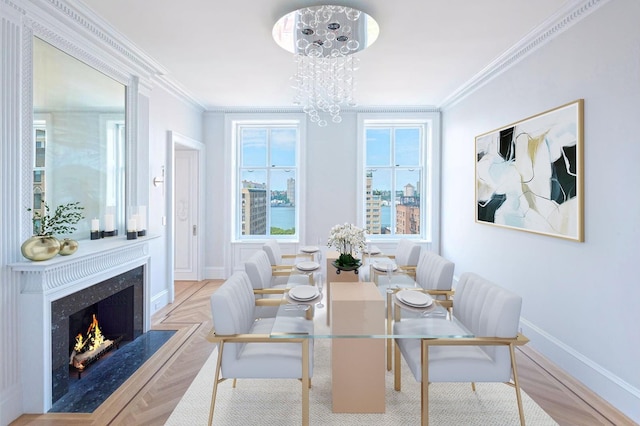 dining room featuring baseboards, a premium fireplace, an inviting chandelier, and crown molding