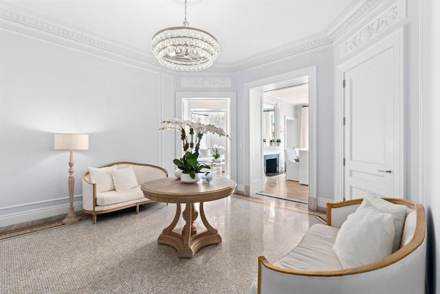 sitting room featuring crown molding and an inviting chandelier