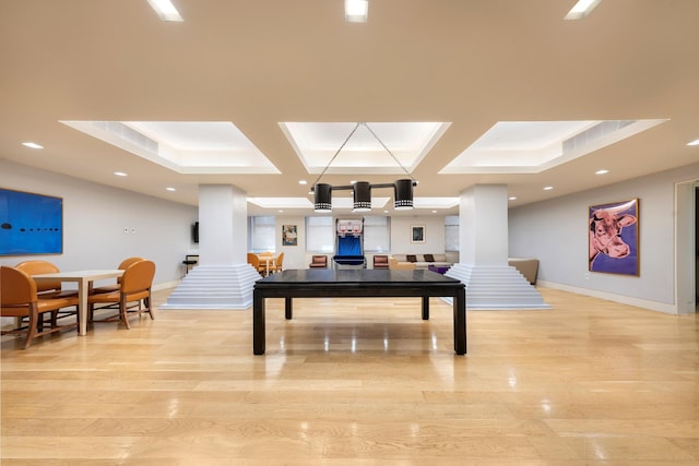 recreation room featuring baseboards, coffered ceiling, light wood-type flooring, ornate columns, and recessed lighting