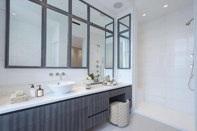 full bathroom with tiled shower and vanity