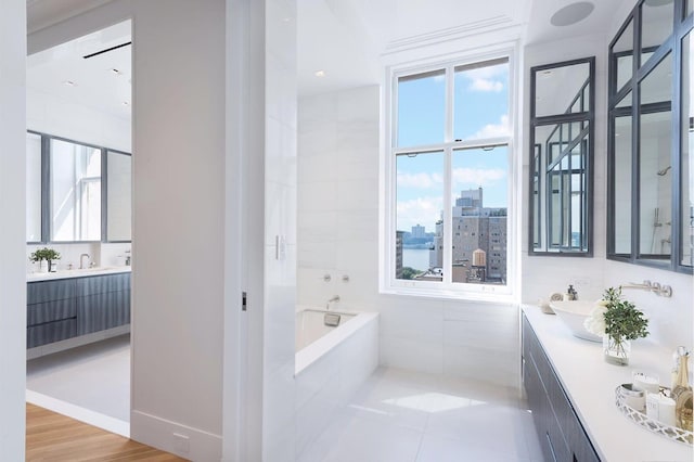 full bath with baseboards, tile patterned flooring, a city view, vanity, and a bath