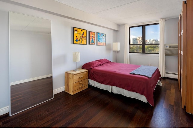 bedroom featuring baseboard heating and dark hardwood / wood-style flooring