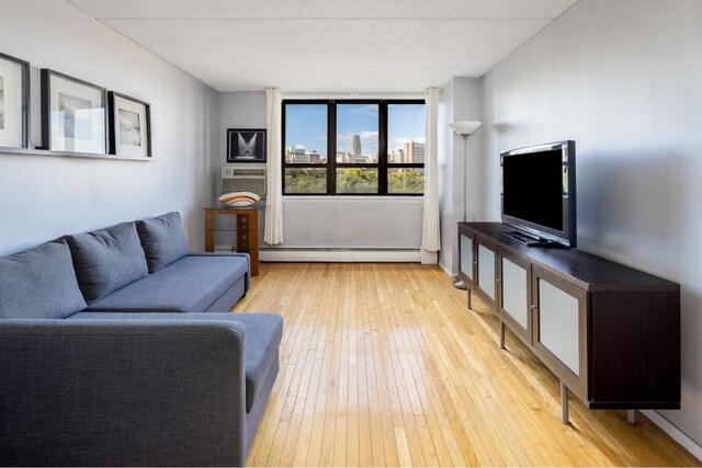 bedroom with baseboard heating and dark wood-type flooring