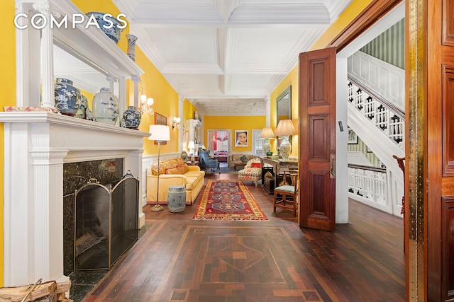 interior space with beamed ceiling, dark wood finished floors, ornamental molding, stairway, and coffered ceiling