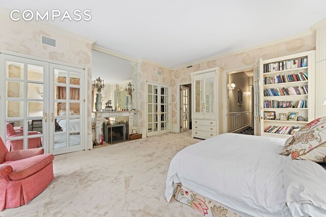 carpeted bedroom with ornamental molding, a fireplace, visible vents, and wallpapered walls